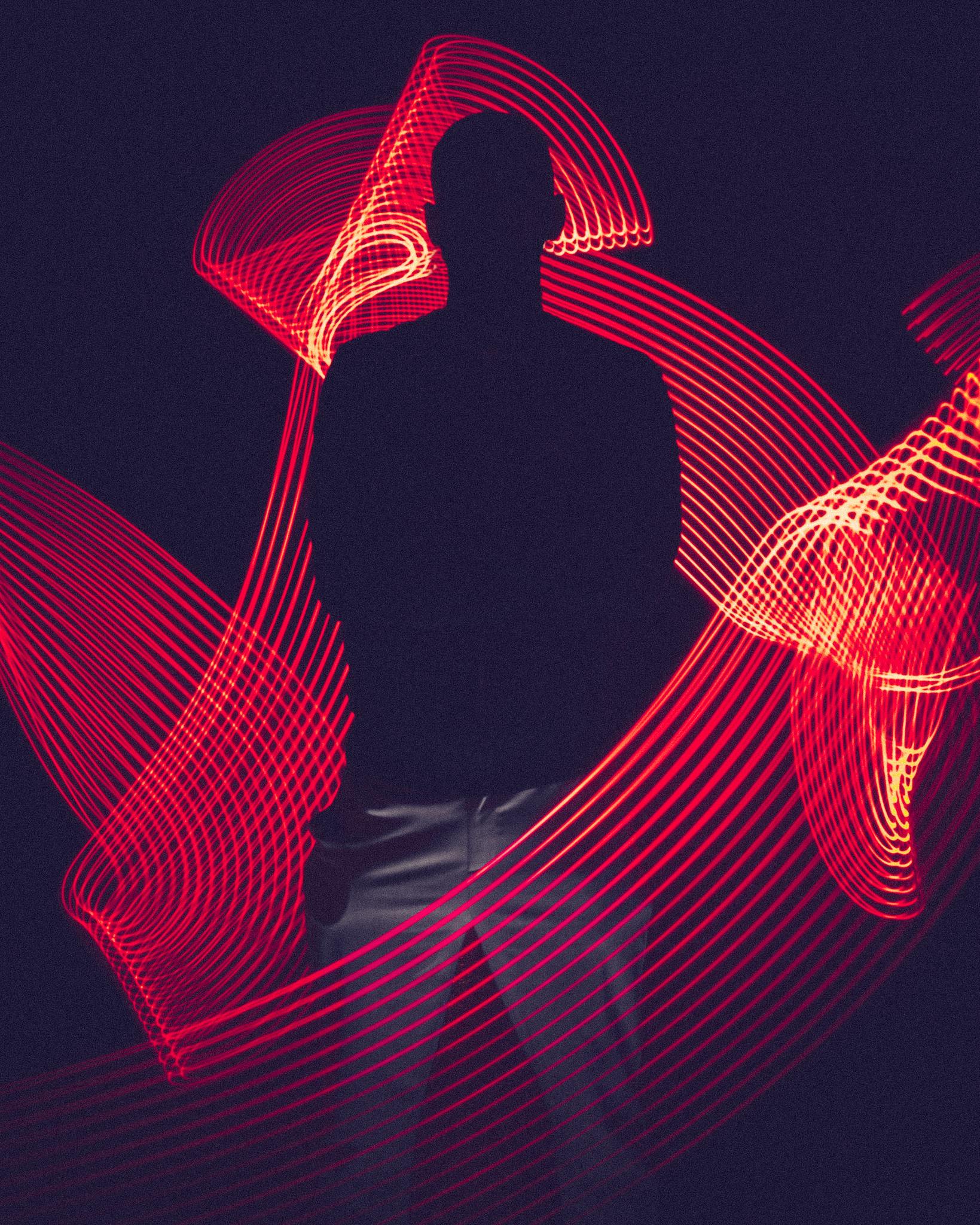 Albums 3 A silhouette of a person surrounded by artistic red light trails, creating a dynamic visual effect.