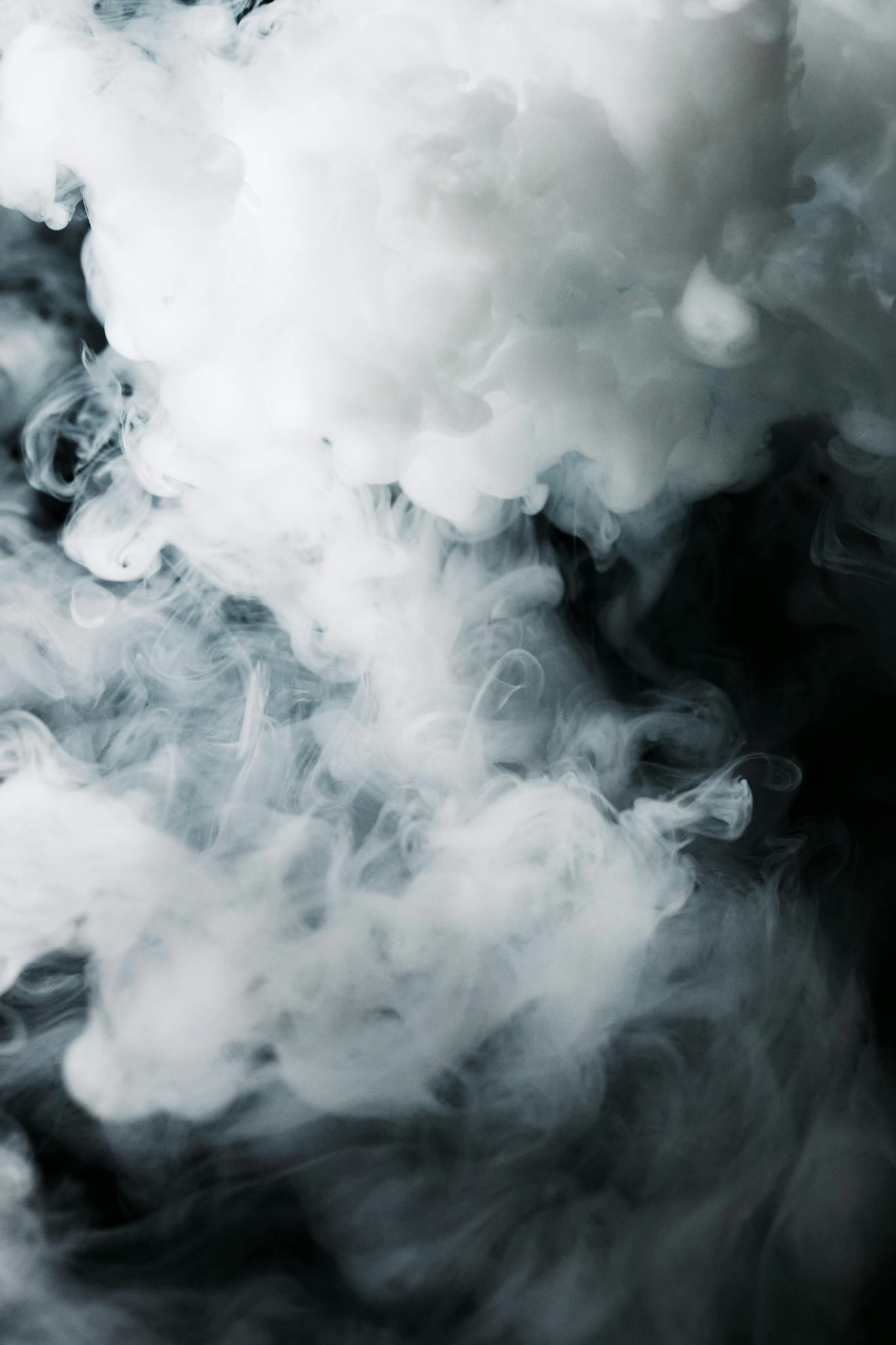 An ethereal composition of wispy smoke clouds against a dark background, creating a mysterious ambiance.
